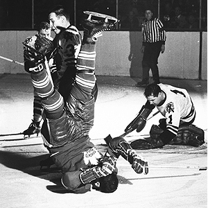 Pierre Pilote flips Gerry James of the Leafs as goalie Glenn Hall covers up courtesy Hockey Hall of Fame